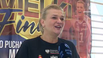 Małgorzata Glinka udzielająca wywiadu na tle baneru reklamowego.