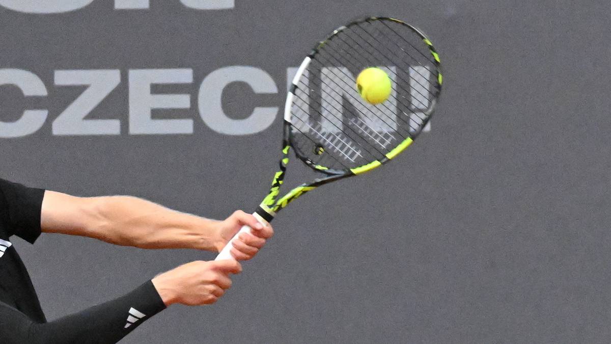 Tenisista uderza piłkę rakietą podczas meczu finałowego turnieju tenisowego.