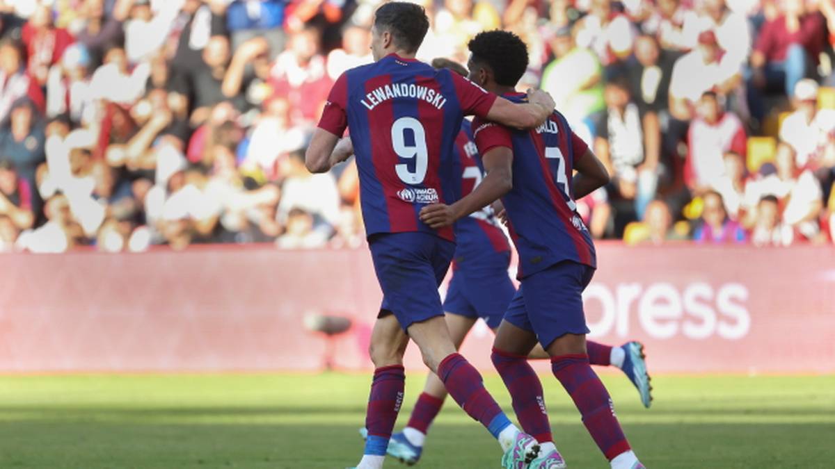 Piłkarze FC Barcelony świętujący bramkę na tle trybun stadionu.