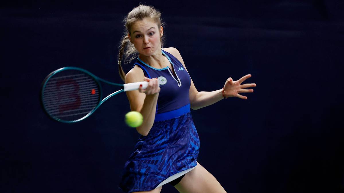 Tenisistka w akcji, uderzająca piłkę rakietą.