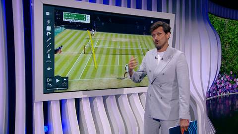 Maciej Syn&oacute;wka stoi przed dużym ekranem, na kt&oacute;rym wyświetlona jest analiza meczu tenisowego Igi Świątek z Alexandrą Eala z Wimbledonu. Syn&oacute;wka wskazuje na elementy taktyczne na ekranie.
