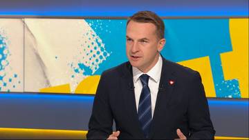 Mężczyzna w garniturze i krawacie wypowiadający się w telewizyjnym studiu.