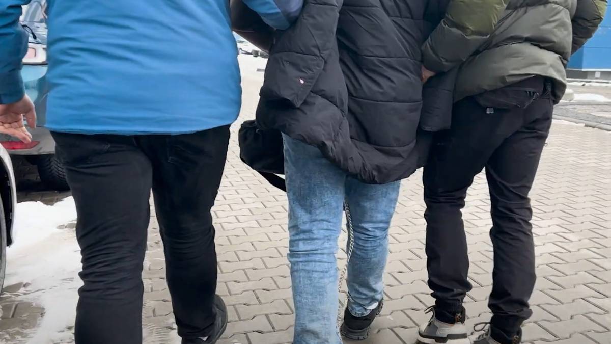 Trzech mężczyzn prowadzonych przez policjant&oacute;w.