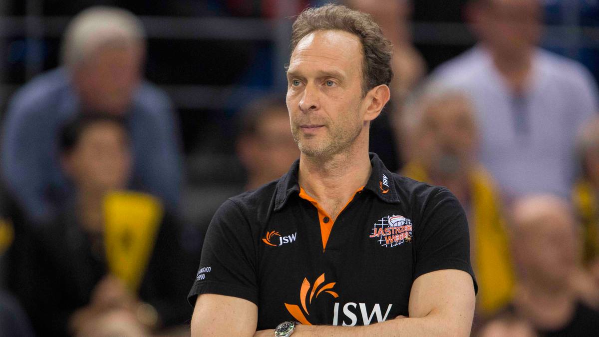 Portret trenera siatkarskiego Lorenzo Bernardiego w czarno-pomarańczowej koszulce sportowej z logo drużyny.