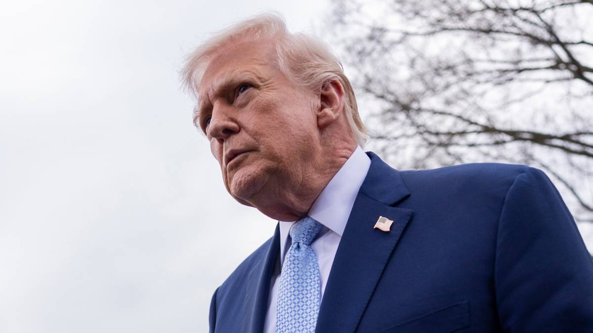 Donald Trump w niebieskim garniturze i jasnoniebieskim krawacie, patrzący w bok.