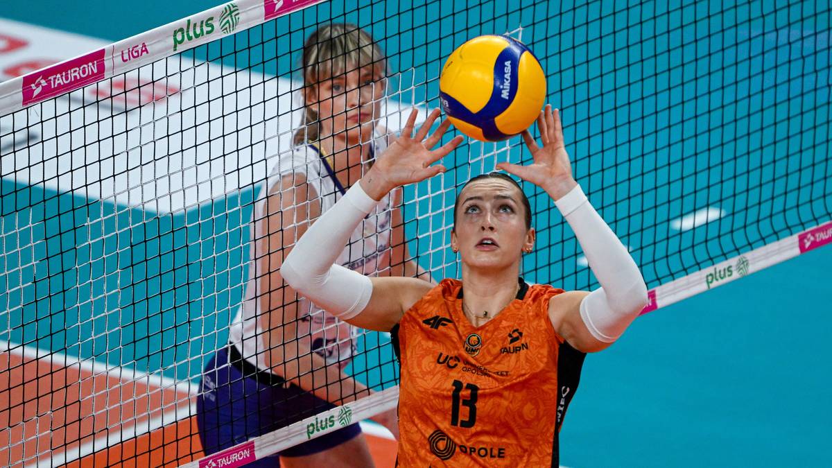 Dwie siatkarki na boisku, jedna z nich wystawia piłkę do ataku.