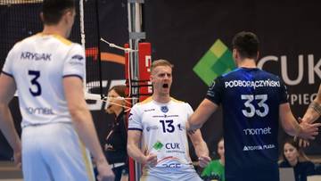 Trzech siatkarzy na boisku podczas meczu siatk&oacute;wki, jeden z nich świętuje zdobyty punkt.