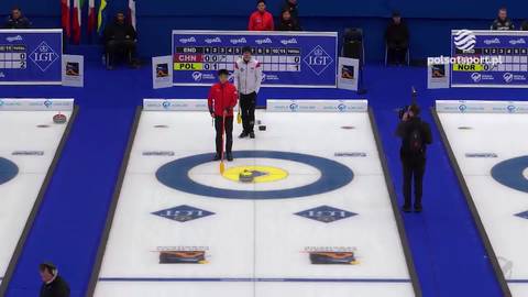 Fragment meczu curlingowego między Polską a Chinami. Dw&oacute;ch zawodnik&oacute;w na lodowym torze, jeden z nich przy kamieniu.