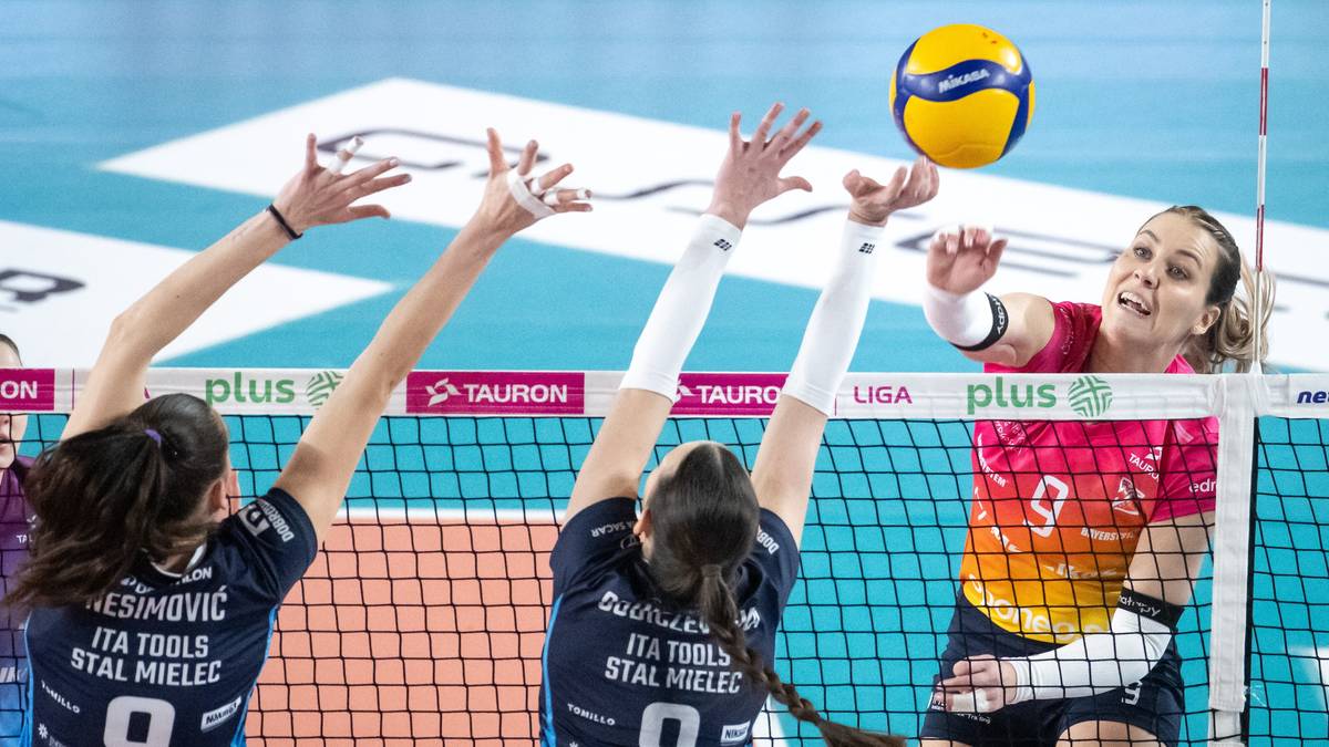 Siatkarki w akcji podczas meczu, zmagające się o piłkę nad siatką.