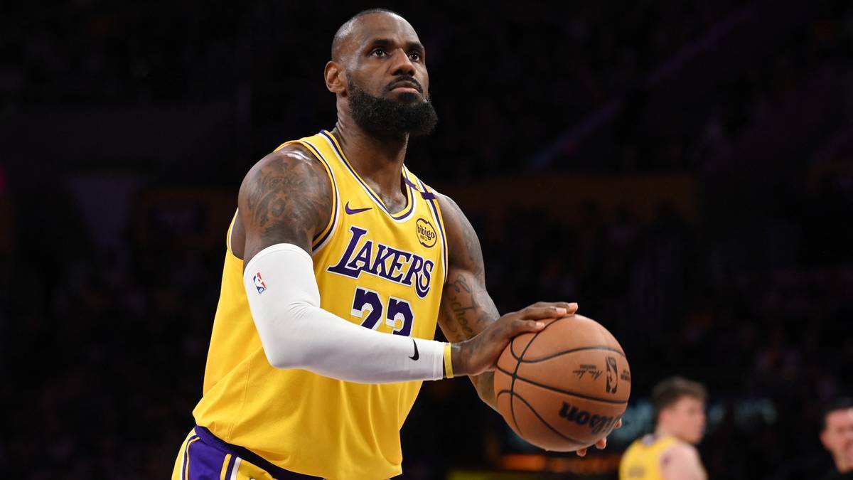 LeBron James w żółtej koszulce Lakers z numerem 23, trzymający piłkę do koszykówki.