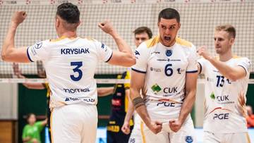 Siatkarze w białych strojach świętują zwycięstwo, jeden z nich krzyczy z radości.