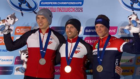 Trzech mężczyzn na podium podczas ceremonii medalowej, trzymających maskotki i medale. Zawodnicy ubrani w stroje sportowe.