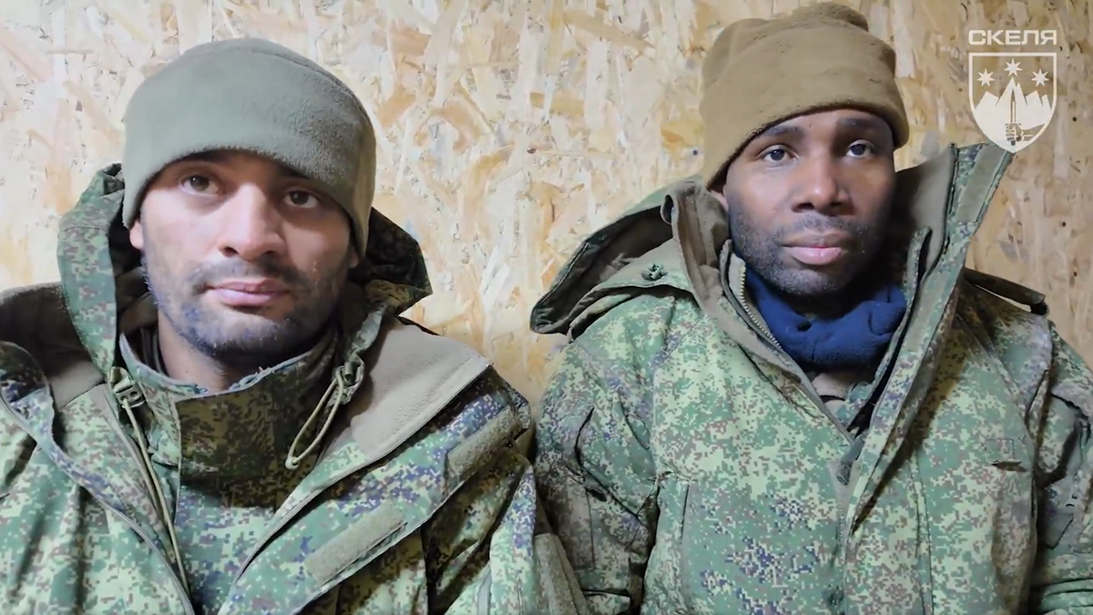 Dw&oacute;ch mężczyzn w mundurach wojskowych, jeden z nich jest ciemnosk&oacute;ry.