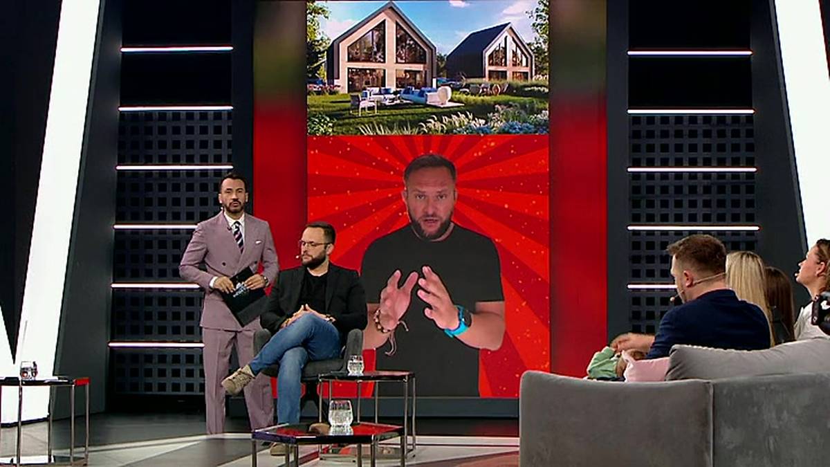 Na ekranie telewizyjnym widoczne są wizualizacje dw&oacute;ch nowoczesnych dom&oacute;w. Poniżej ekranu mężczyzna prowadzi dyskusję.