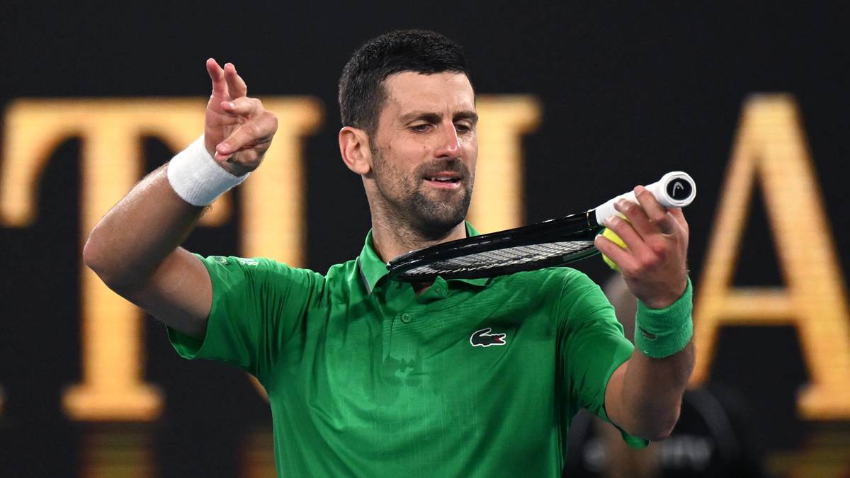 Novak Djoković w zielonej koszulce trzyma rakietę tenisową, pokazując gest radości lub skupienia.