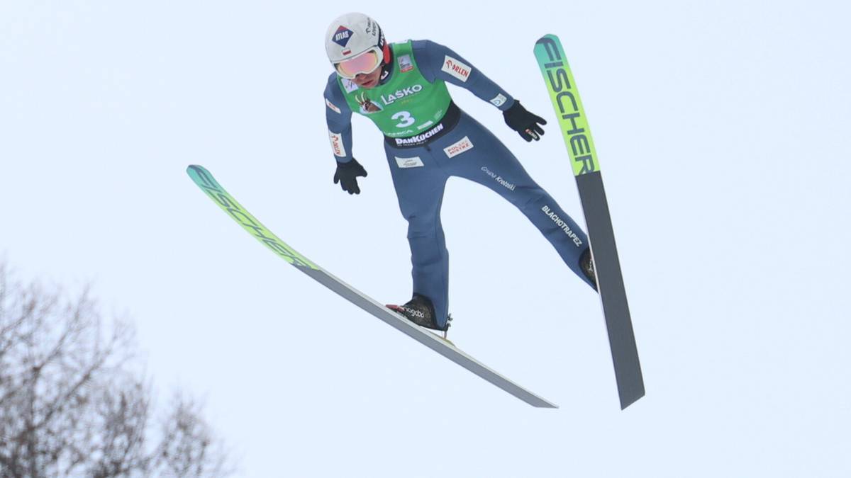 Skoczek narciarski w powietrzu, wykonujący skok na nartach.