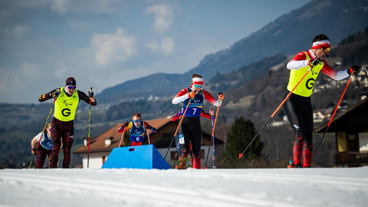 Narciarze biegowi w akcji podczas zawod&oacute;w na ośnieżonym stoku.