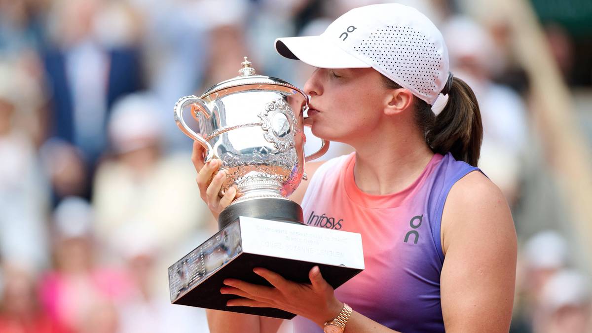 Iga Świątek całuje trofeum po zwycięstwie w turnieju Roland Garros.