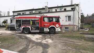 Czerwony w&oacute;z strażacki przed budynkiem mieszkalnym