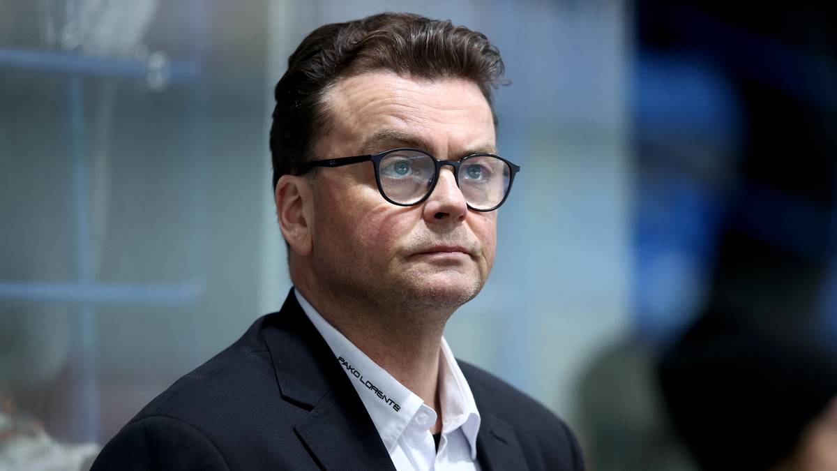 Mężczyzna w garniturze i okularach, patrzący na wprost z poważną miną.