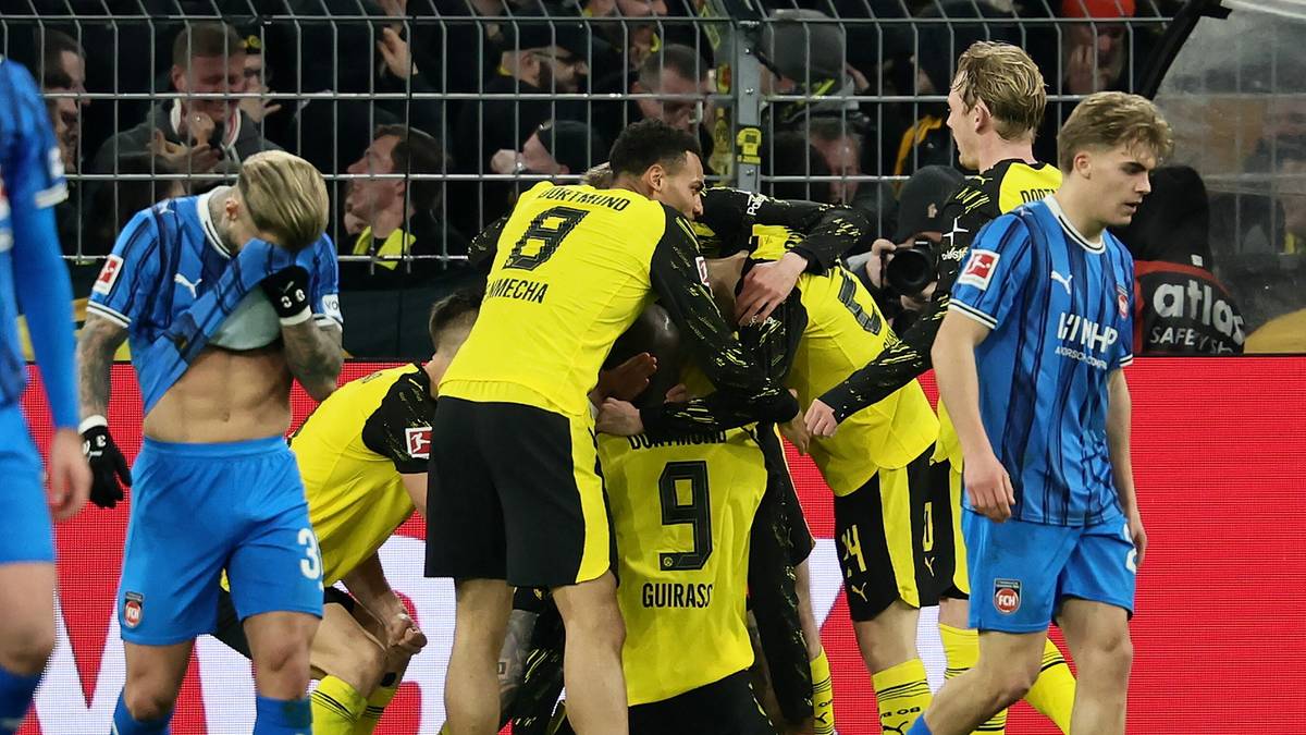 Piłkarze Borussii Dortmund świętują po zdobyciu bramki, otaczając się nawzajem na boisku.