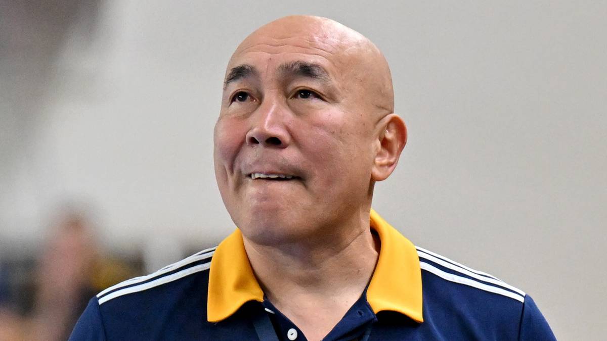 Portret Tałanta Dujszebajewa, trenera piłki ręcznej, w ciemnogranatowej koszulce sportowej z żółtym kołnierzykiem.