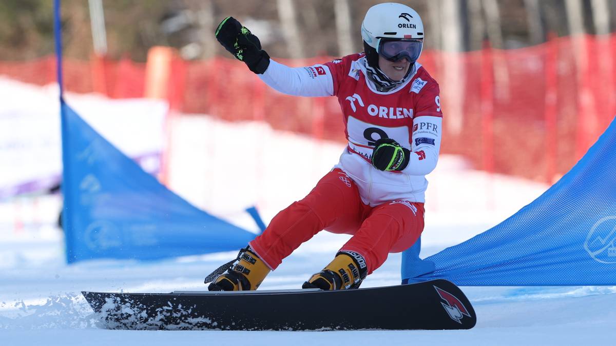 Zawodniczka snowboardu w kombinezonie sportowym jedzie po ośnieżonej trasie zjazdowej.