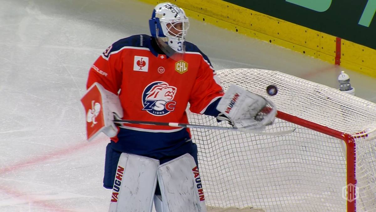 Bramkarz hokejowy w stroju ZSC Lions z krążkiem przed bramką