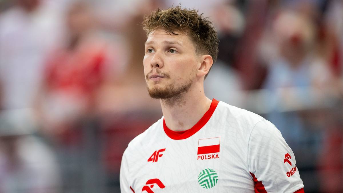 Siatkarz Jakub Kochanowski w białej koszulce z godłem Polski i napisem "POLSKA".