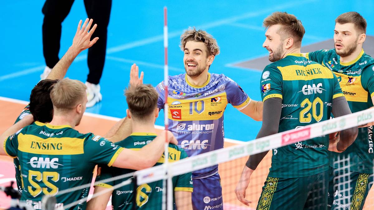 Siatkarze drużyny Aluron CMC Warta Zawiercie świętują zwycięstwo na boisku, podając sobie ręce.