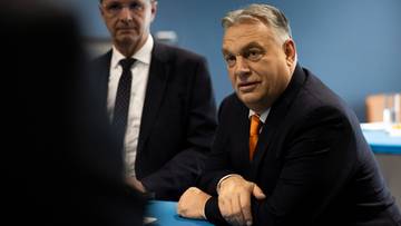 Viktor Orban, premier Węgier, rozmawia z mężczyzną w garniturze.