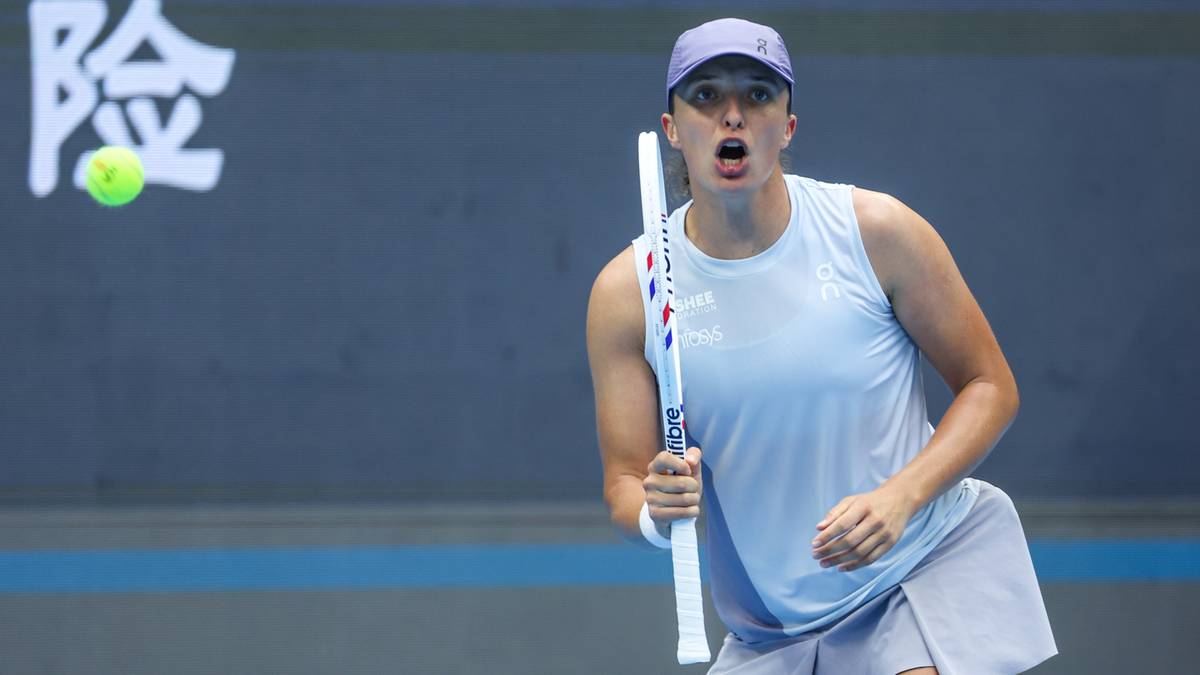 Tenisistka Iga Świątek w akcji, podbijająca piłkę rakietą podczas meczu.