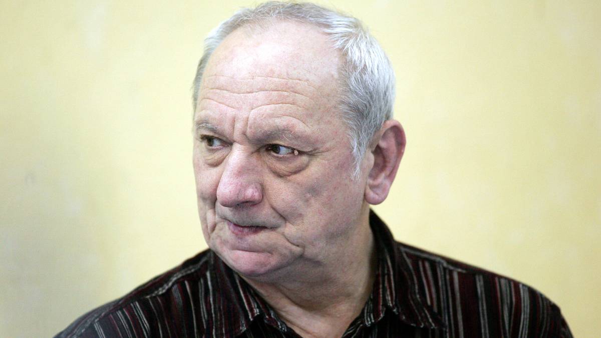 Portret starszego mężczyzny z siwymi włosami, patrzącego w bok.