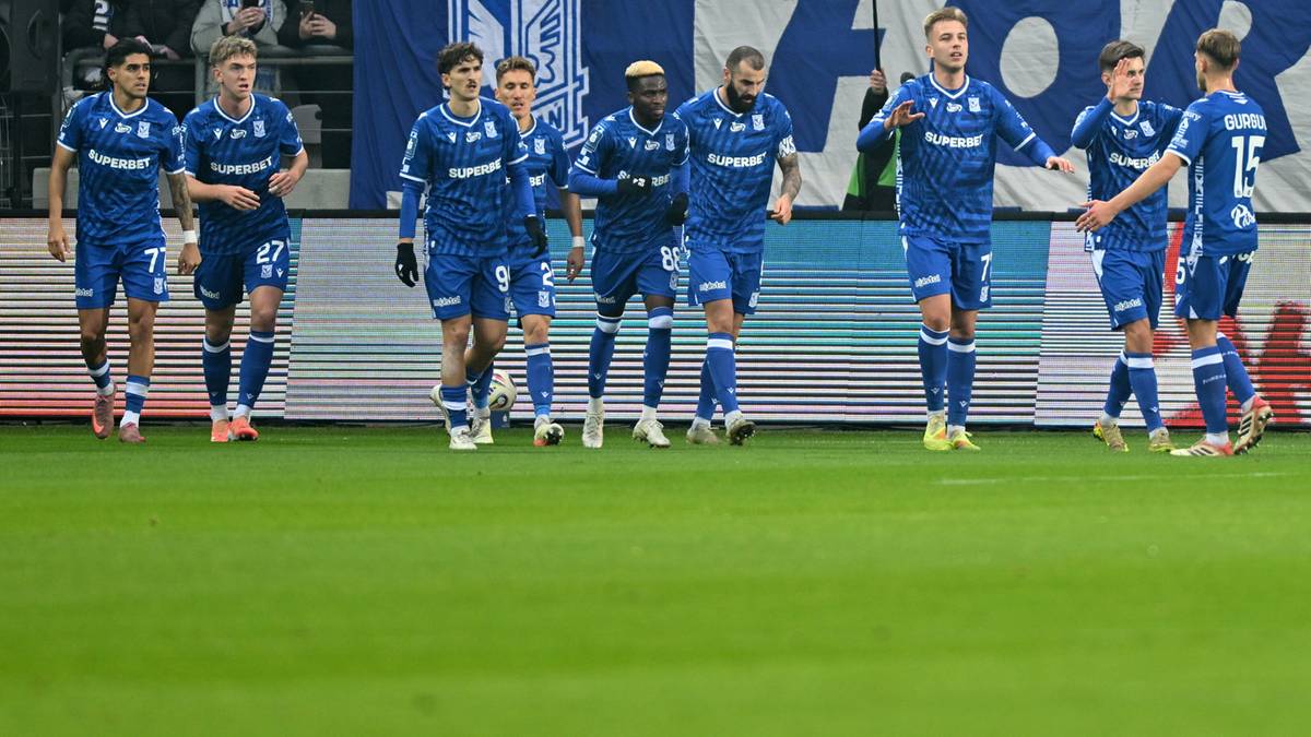 Piłkarze Lecha Poznań świętujący bramkę na boisku.