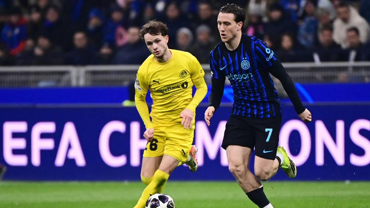 Dw&oacute;ch piłkarzy rywalizuje o piłkę na boisku piłkarskim. Jeden gracz jest w ż&oacute;łtej koszulce, a drugi w granatowej z numerem 7.