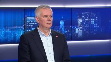 Mężczyzna w ciemnej marynarce i jasnej koszuli.