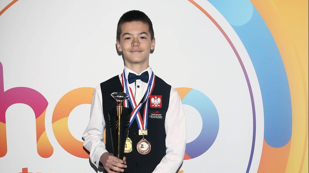 Michał Szubarczyk, młody snookerzysta, pozuje z pucharem i medalem