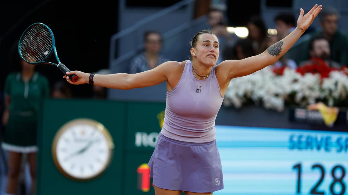 Aryna Sabalenka po wygranym punkcie na korcie tenisowym, z uniesionymi rękami w geście triumfu.