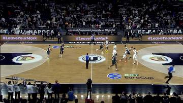 Mecz koszykówki U-BT Kluż-Napoka kontra WKS Śląsk Wrocław na boisku z graczami w akcji i kibicami na trybunach.