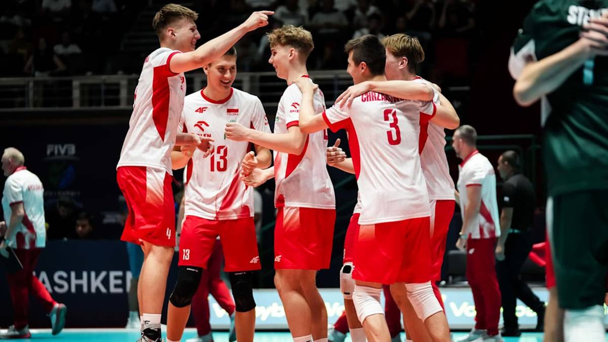 Grupa polskich siatkarzy w białych i czerwonych strojach świętuje sukces na boisku, obejmując się i unosząc ręce w geście radości.