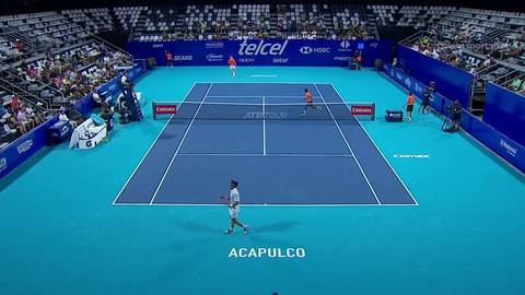 Kort tenisowy z dwoma zawodnikami w trakcie meczu, trybuny pełne widz&oacute;w, widoczny napis ACAPULCO.