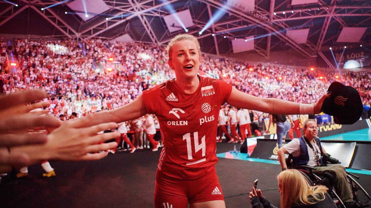 Joanna Wołosz, siatkarka w czerwonej koszulce z numerem 14, świętuje z kibicami.