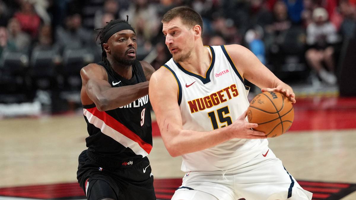 Koszykarz Denver Nuggets Nikola Jokić z piłką, broniony przez zawodnika Portland Trail Blazers.