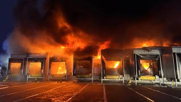 Płonący magazyn firmy Schenker w nocy z widocznymi płomieniami i dymem