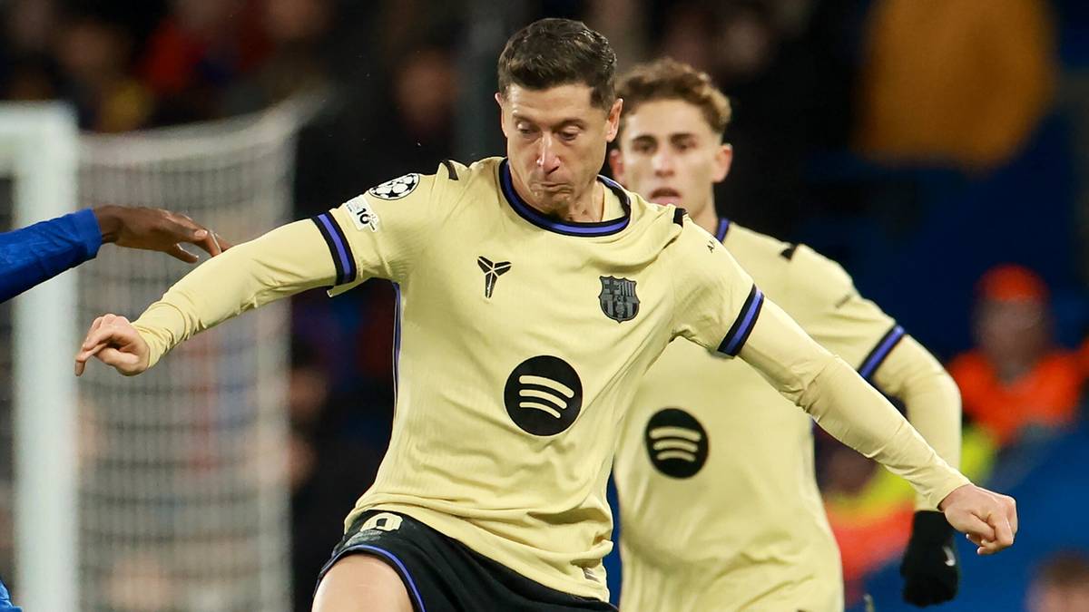 Dwóch piłkarzy walczy o piłkę na zielonym boisku.