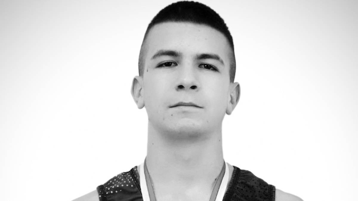 Portret czarno-biały młodego polskiego sportowca, patrzącego prosto przed siebie.