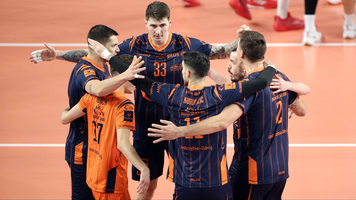 Siatkarze Jastrzębskiego Węgla w ciemnogranatowych strojach świętują zwycięstwo.