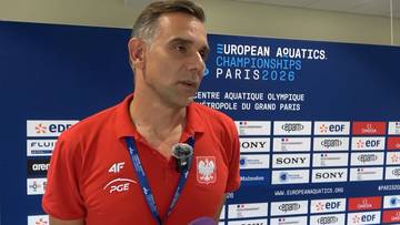 Bartosz Kizierowski w czerwonej koszulce z polskim godłem i logo sponsorskimi, stojący przed niebieską ścianką z napisem "European Aquatics Championships Paris 2026".