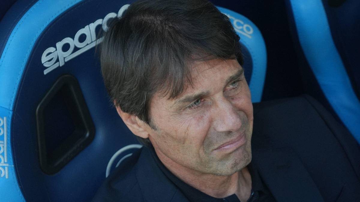 Portret Antonio Conte, trenera piłkarskiego, siedzącego na ławce rezerwowych.