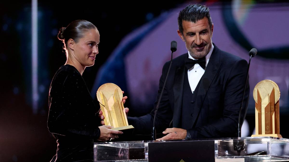 Piłkarka Ewa Pajor odbiera złotą nagrodę z rąk mężczyzny w garniturze.